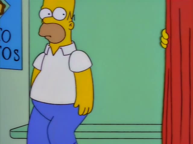 Homer Simpson sits on a green bench beside a man in a dark suit, black tie and grey fedora who is not one of the regulars