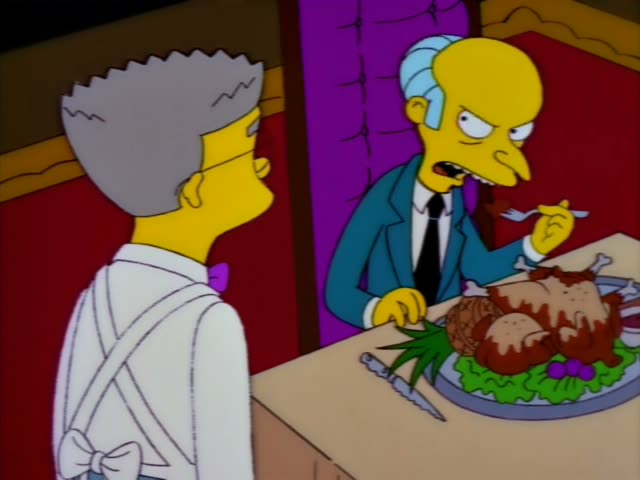 Mr. Burns sits at a dining table carving and eating a roast turkey on a platter while his thin assistant Smithers stands…
