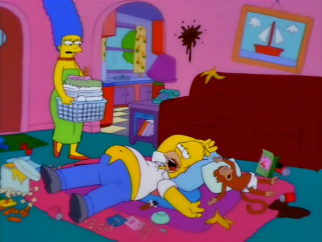 Marge stands in a pink room holding a laundry basket of folded clothes while Homer lies sprawled on a pink rug…