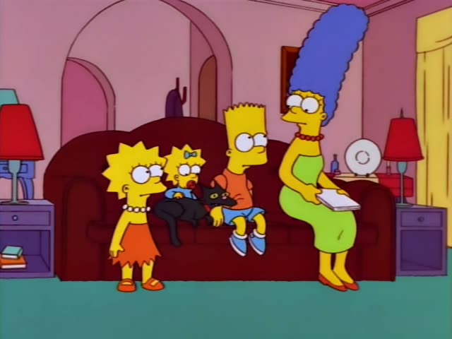 Lisa, Maggie, Bart and Marge sit or stand in the living room around the brown couch, with Maggie holding a black cat…