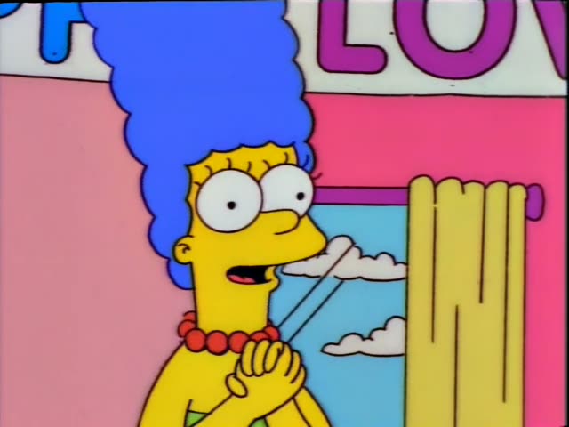 Marge stands in a pink living room decorated for the HAPPY LOVE DAY banner, while Bart sits on a green armchair and Maggie…