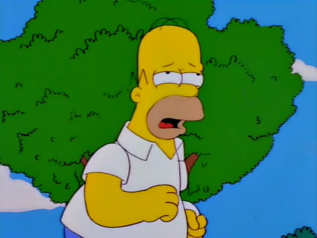 Homer holds up a sign reading SIMPSON on a grassy field, then runs ahead of a group of children chasing him, with Bart among…