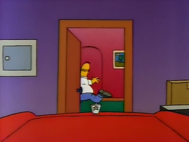 Homer stands in a purple bedroom with a red bed and a cardboard box, looking startled and gesturing with one arm…