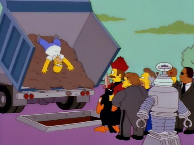 Homer is tossed in the bed of a dump truck while a crowd of mourners in dark suits, a red-robed man with a red hat…