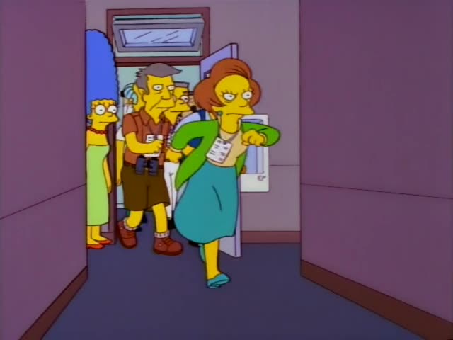 Marge, Mrs. Krabappel and a one-off man in a brown shirt, shorts and binoculars, all wearing name tags, file…