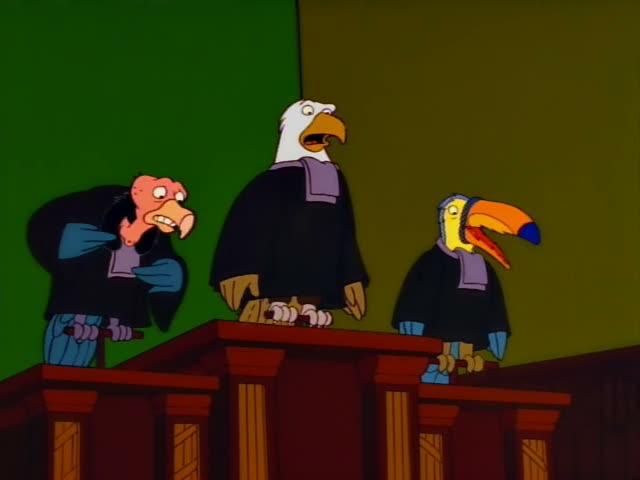 Three bird characters in black judges' robes with purple collars stand behind a wooden bench against a green and olive…