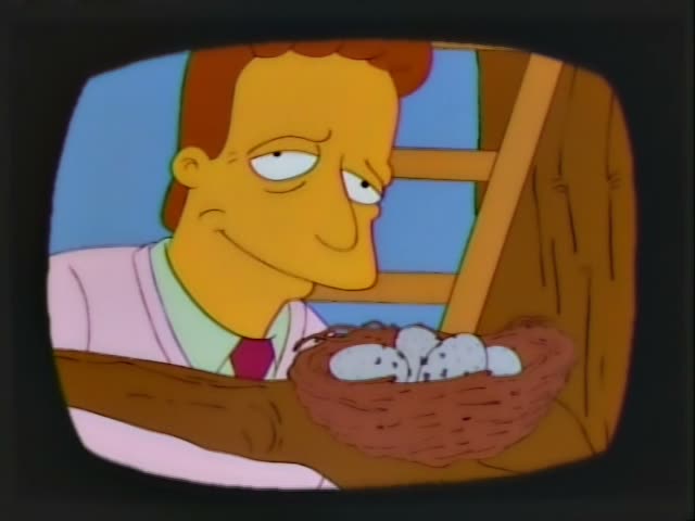 Troy McClure first stands in a pink jacket and maroon tie beside a wooden ledge holding a nest of white eggs, smiling…