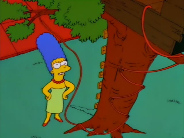Marge Simpson stands at the base of a tree with her hands on her hips, looking up at a treehouse, with a red rope hanging…
