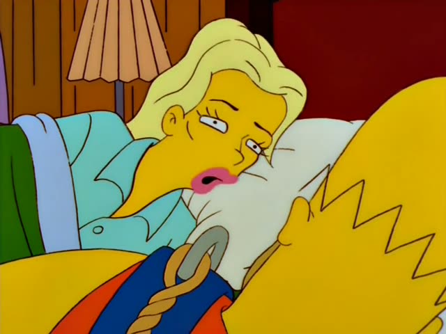 Homer and a blonde woman in a light blue nightgown with pink lipstick are first seen in a close-up in a wood-paneled…