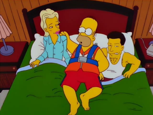 Homer Simpson sits between a blonde woman in a light blue blouse and a dark-haired man in a white tank top on a bed…