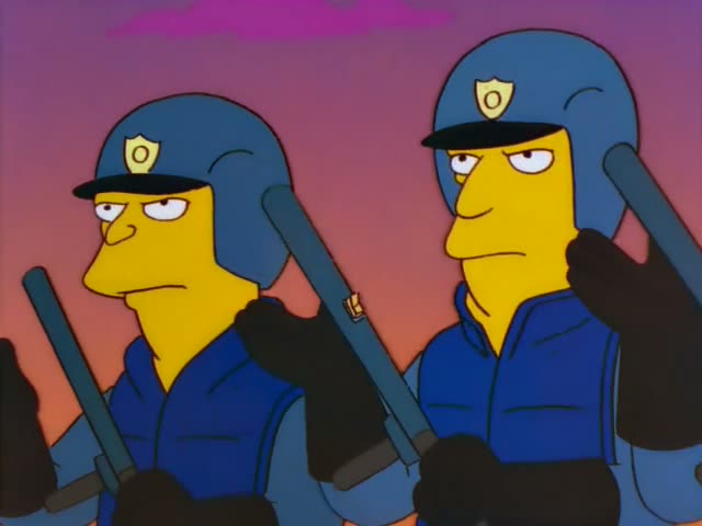 Police officers in blue uniforms and helmets, with the heavy-set Chief Wiggum prominent in the close-ups, hold batons…