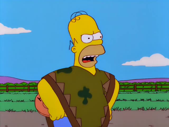 Homer Simpson stands on a dirt path in front of a wooden fence and grassy fields, scowling and gritting his teeth before he…
