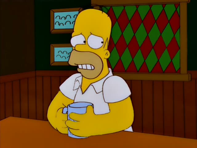 Homer Simpson sits at a bar holding a mug, then is joined by Carl and Lenny, who has spiky black hair and wears a green…