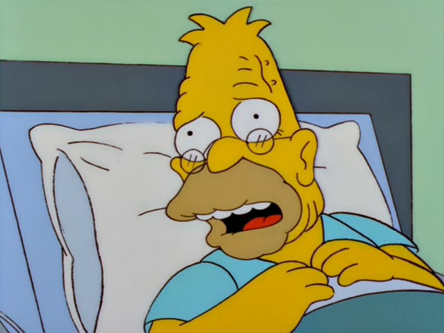 Krusty the clown, in a white lab coat with a head mirror and blue bow tie, stands beside a hospital bed where Grampa lies…