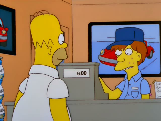 Homer Simpson stands at the counter of a shop with a cash register reading 10.00 while a freckled, red-haired clerk…