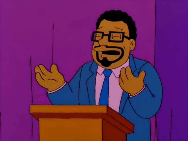A bespectacled Black preacher in a blue suit, pink shirt and blue tie speaks from a wooden podium in a purple tent…
