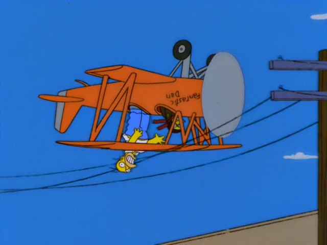 Homer and Marge are in an orange biplane marked "Fantastic Dan" flying over treetops, power lines and a stone bridge