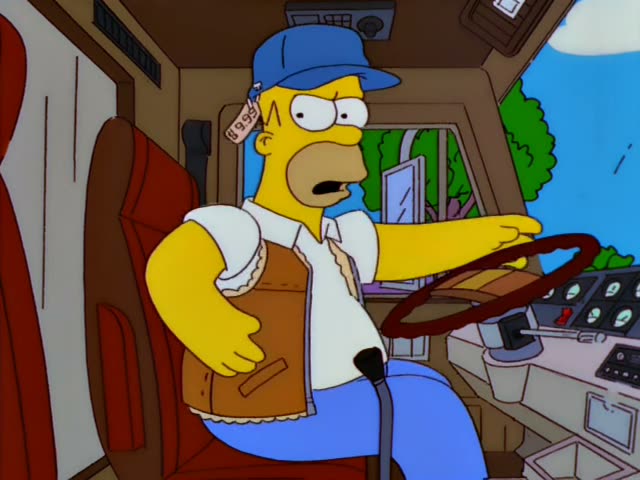 Homer sits at the wheel of a bus while Bart watches from the passenger seat