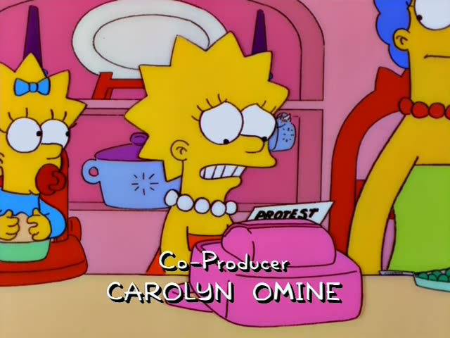 Lisa Simpson sits at the dinner table in a pink room with a pearl necklace, looking uneasy and speaking with her mouth open…