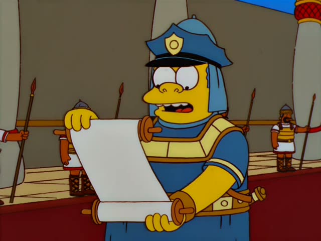 Chief Wiggum unrolls and reads a long scroll on a red-carpeted hall while armored guards with spears stand behind him